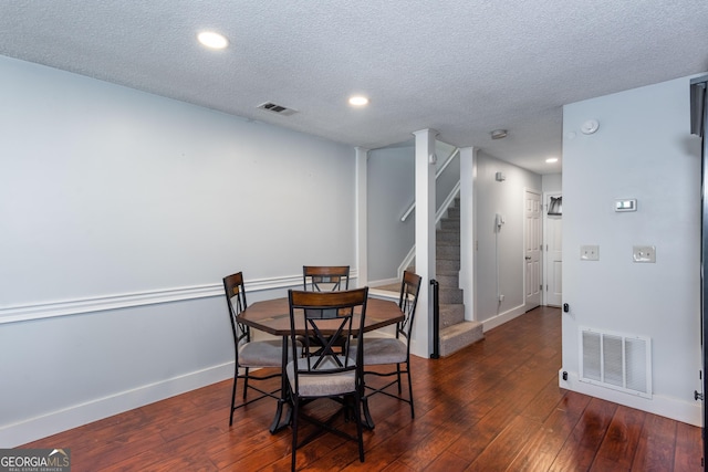 dining room featuring visible vents, stairway, baseboards, and hardwood / wood-style floors