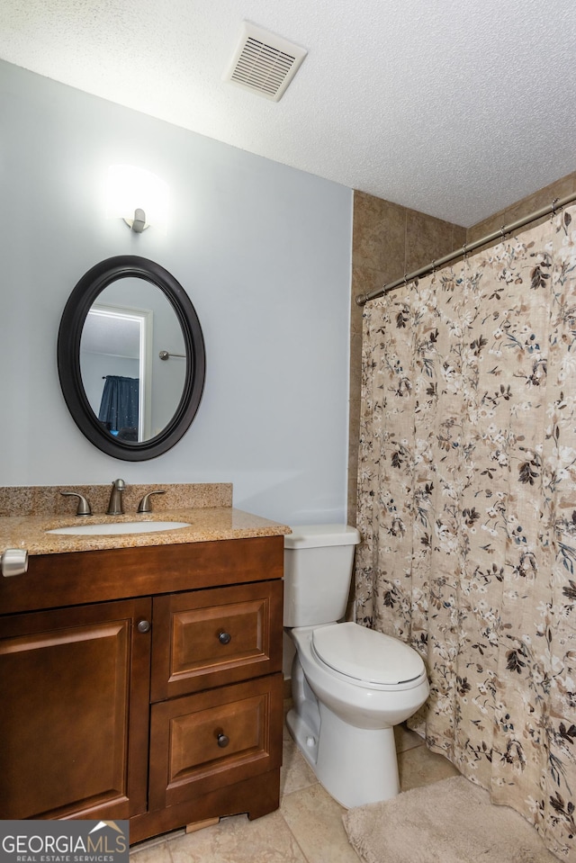 full bathroom featuring visible vents, toilet, vanity, tile patterned floors, and a textured ceiling