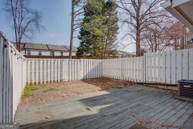 wooden terrace featuring central AC unit and a fenced backyard