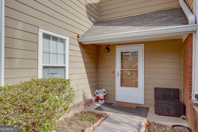 entrance to property with roof with shingles