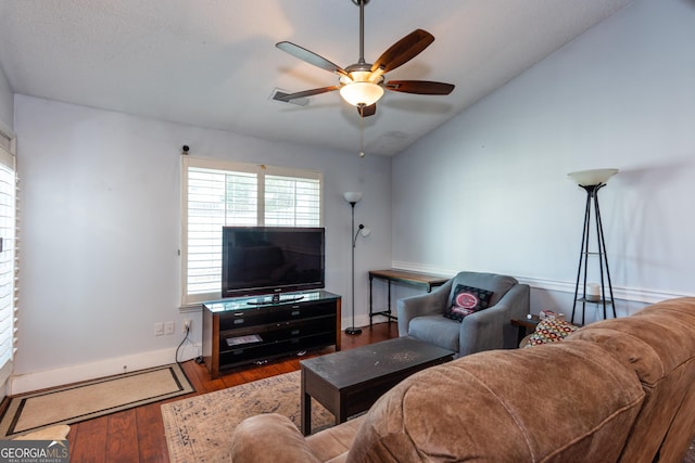 living area featuring baseboards, lofted ceiling, ceiling fan, and wood finished floors