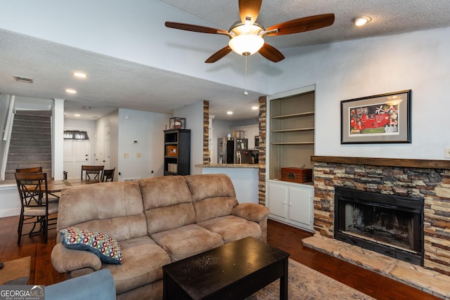 living area with dark wood finished floors, stairway, a textured ceiling, and a ceiling fan