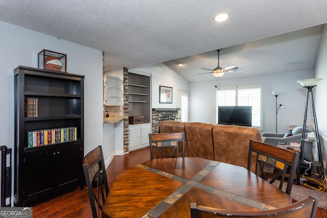 dining space featuring a textured ceiling, lofted ceiling, dark wood-style flooring, and ceiling fan