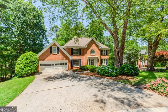 2205 Parliament Dr, Lawrenceville, GA 30043 - colonial-style house with concrete driveway, a front lawn, a garage, and brick siding