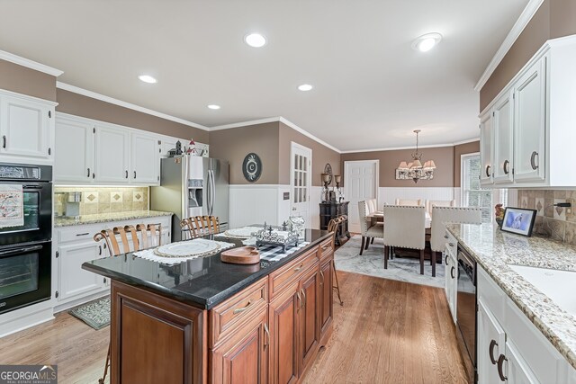 2205 Parliament Dr, Lawrenceville, GA 30043 - kitchen with stainless steel fridge, light wood-style floors, white cabinetry, ornamental molding, and recessed lighting