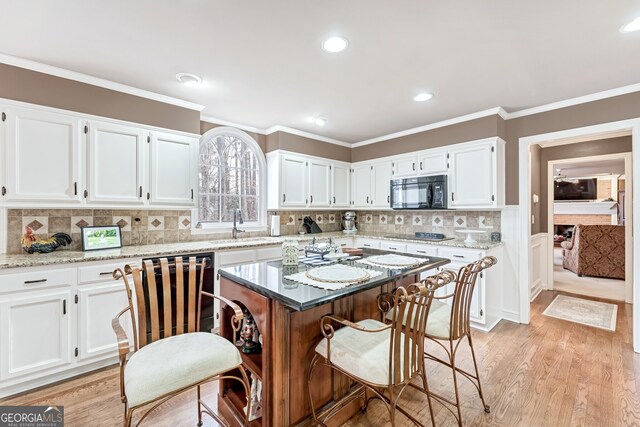 2205 Parliament Dr, Lawrenceville, GA 30043 - kitchen with black appliances, white cabinetry, a sink, crown molding, and recessed lighting