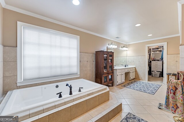 2205 Parliament Dr, Lawrenceville, GA 30043 - bathroom featuring tile walls, vanity, a spacious closet, a garden tub, and tile patterned floors