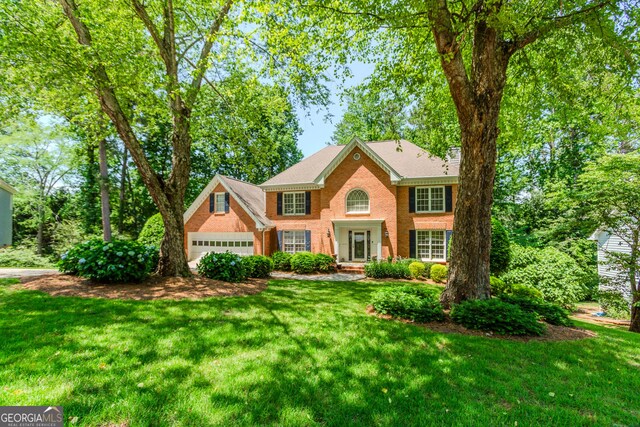 2205 Parliament Dr, Lawrenceville, GA 30043 - view of front facade with brick siding, a front lawn, and a garage