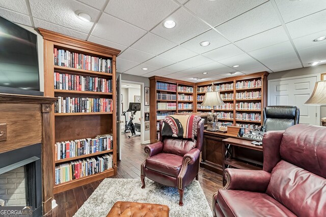 2205 Parliament Dr, Lawrenceville, GA 30043 - sitting room with a fireplace, wood finished floors, recessed lighting, a paneled ceiling, and built in features