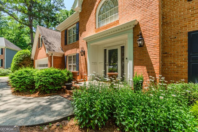 2205 Parliament Dr, Lawrenceville, GA 30043 - view of exterior entry with brick siding and a shingled roof
