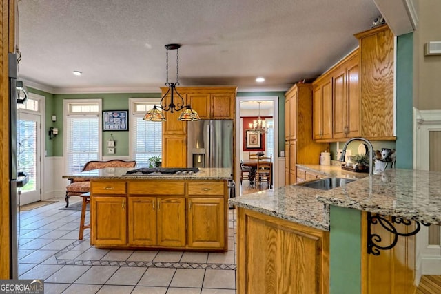 kitchen featuring light tile patterned floors, ornamental molding, a sink, stainless steel refrigerator with ice dispenser, and a chandelier