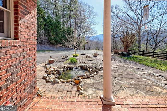 view of patio / terrace with a mountain view and fence