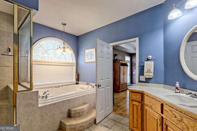 bathroom featuring tile patterned floors, vanity, a garden tub, and a shower stall