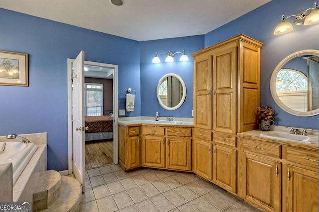 ensuite bathroom with a wealth of natural light, double vanity, and a sink