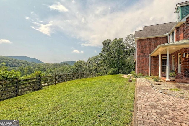 view of yard featuring a mountain view and fence