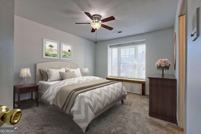 bedroom featuring visible vents, light colored carpet, and a ceiling fan