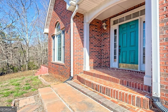 entrance to property featuring brick siding