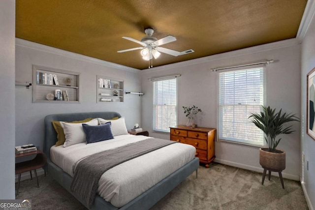 carpeted bedroom featuring visible vents, baseboards, a ceiling fan, and crown molding