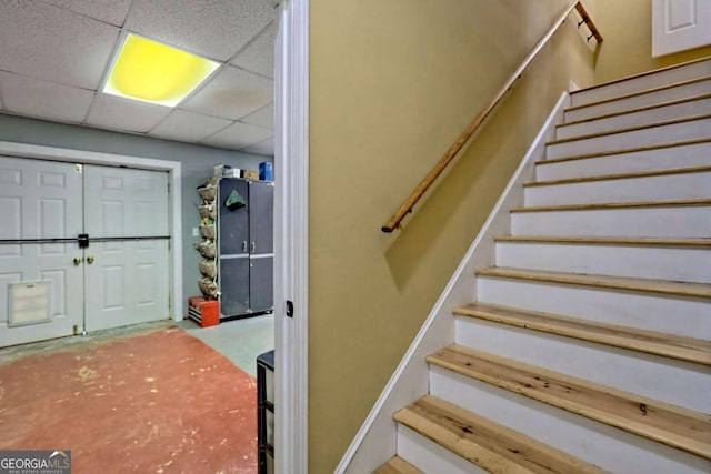 staircase featuring a drop ceiling