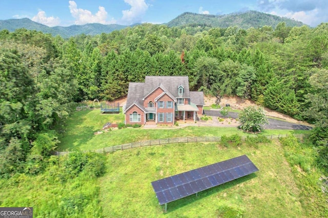 drone / aerial view with a mountain view and a view of trees