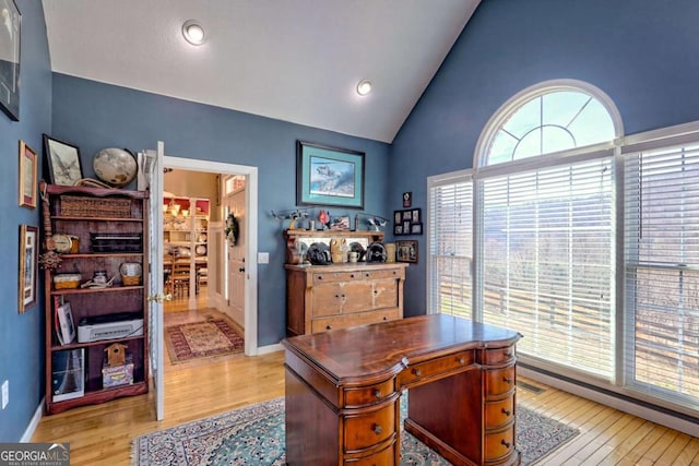 home office featuring visible vents, baseboards, high vaulted ceiling, and light wood finished floors