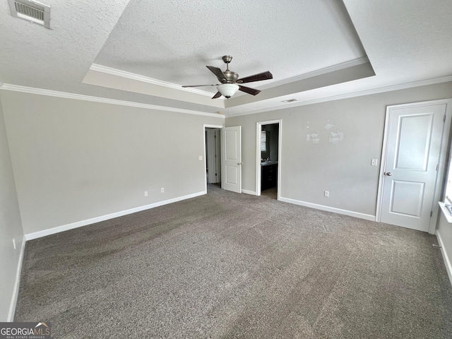 unfurnished bedroom with visible vents, crown molding, carpet flooring, a textured ceiling, and a raised ceiling