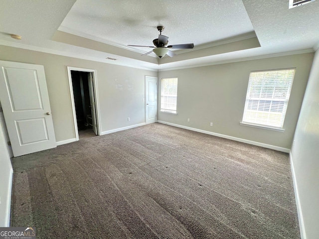 unfurnished bedroom featuring baseboards, carpet floors, crown molding, a textured ceiling, and a raised ceiling