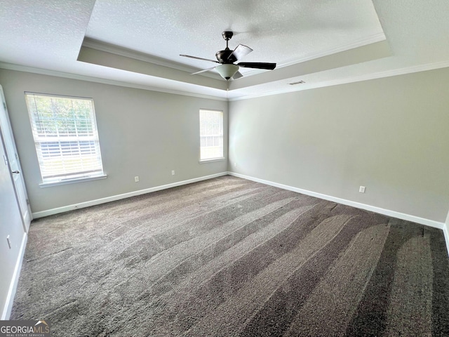 carpeted empty room with a tray ceiling, baseboards, a textured ceiling, and ornamental molding