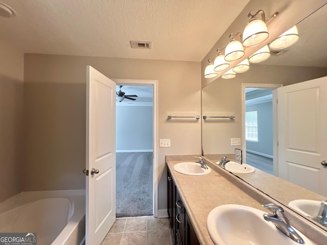 bathroom with a sink, visible vents, and a textured ceiling