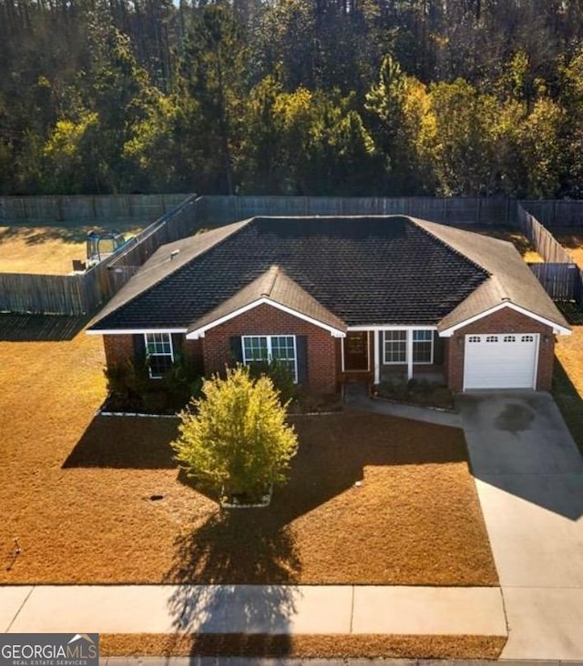 single story home with brick siding, driveway, a garage, and fence