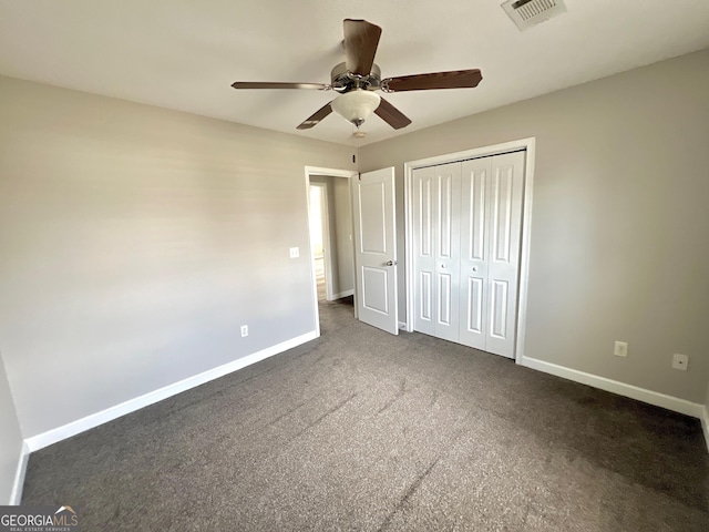 unfurnished bedroom with a ceiling fan, baseboards, visible vents, a closet, and dark colored carpet