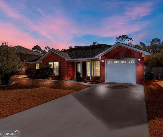 ranch-style house with concrete driveway, an attached garage, and brick siding