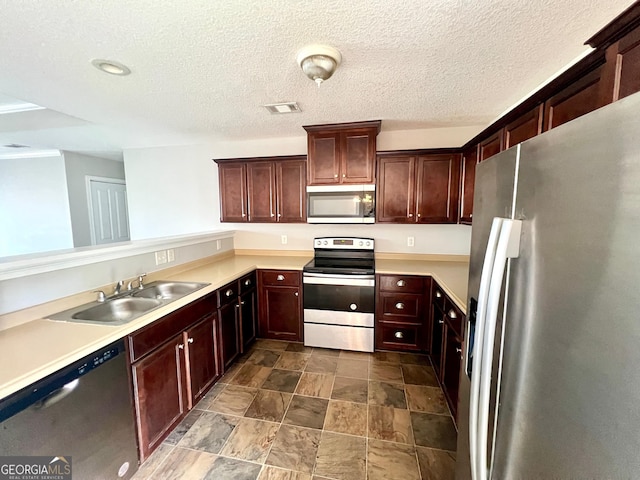 kitchen with visible vents, light countertops, appliances with stainless steel finishes, a textured ceiling, and a sink