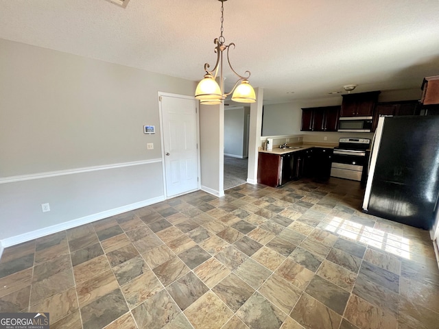 kitchen with baseboards, light countertops, stainless steel appliances, hanging light fixtures, and a textured ceiling