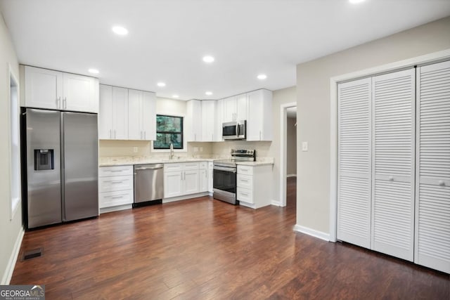 kitchen featuring a sink, white cabinets, dark wood-style flooring, and stainless steel appliances