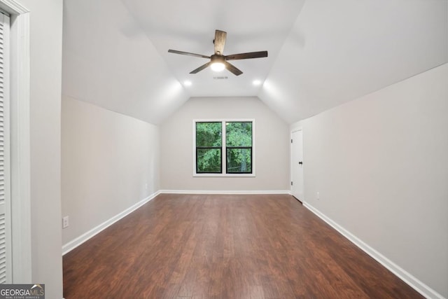 additional living space with visible vents, ceiling fan, baseboards, dark wood finished floors, and vaulted ceiling