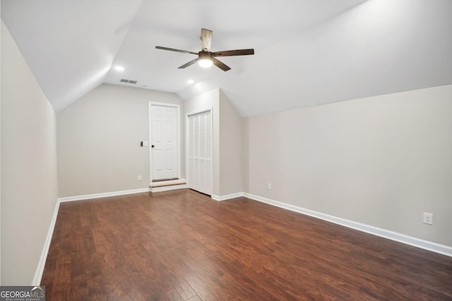 additional living space featuring visible vents, dark wood finished floors, baseboards, lofted ceiling, and ceiling fan