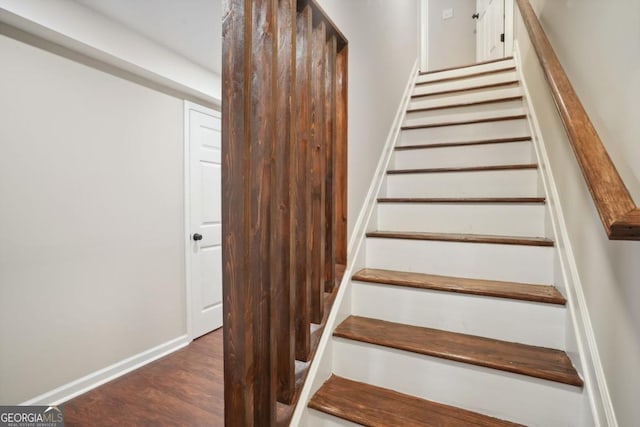 staircase with baseboards and wood finished floors