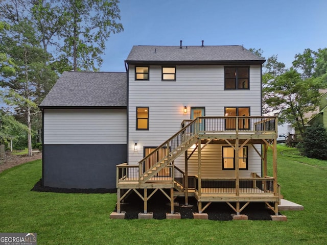 rear view of property with a yard, stairway, a shingled roof, and a deck