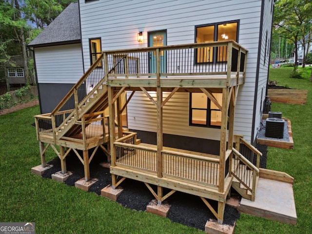 back of house with central air condition unit, a lawn, stairway, a shingled roof, and a wooden deck