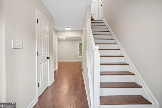 stairs featuring wood finished floors and baseboards