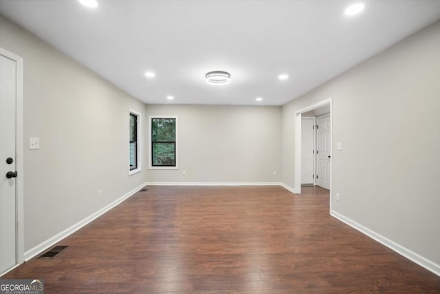 spare room with visible vents, recessed lighting, dark wood-type flooring, and baseboards