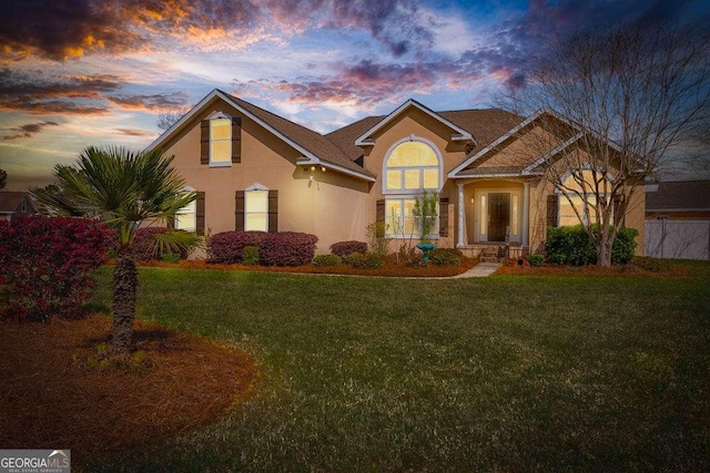 view of front of house featuring stucco siding and a front yard