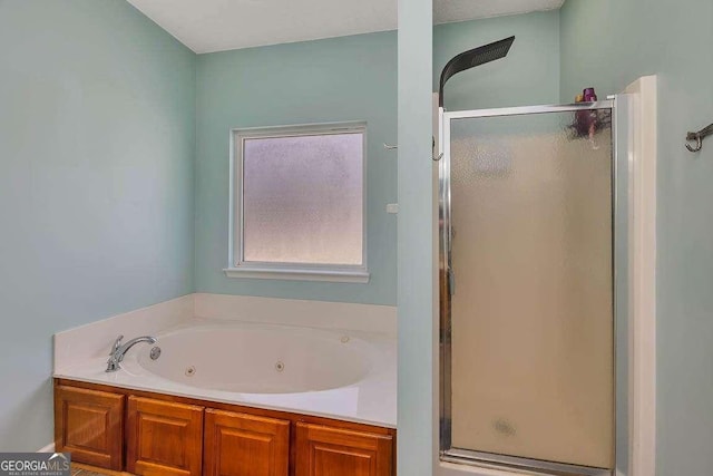 bathroom featuring a tub with jets and a stall shower