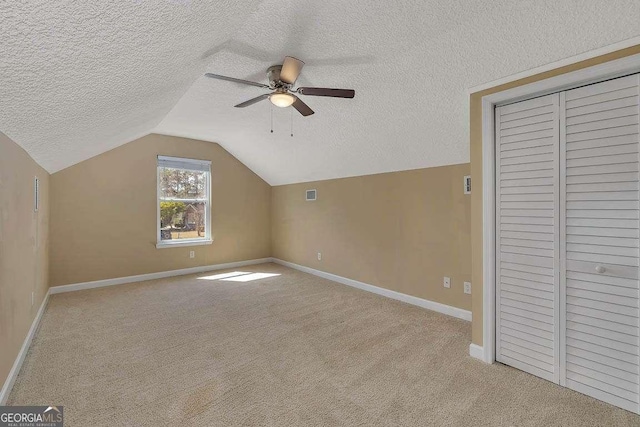 bonus room with a textured ceiling, ceiling fan, carpet flooring, and vaulted ceiling