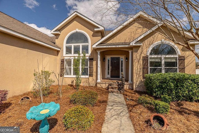 view of exterior entry featuring stucco siding