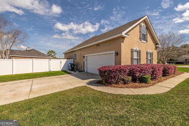 view of home's exterior featuring fence, concrete driveway, stucco siding, a lawn, and a garage