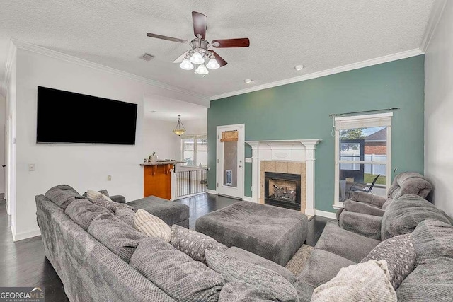 living room with visible vents, a textured ceiling, crown molding, ceiling fan, and dark wood-style flooring