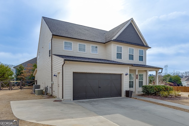 view of front of property with cooling unit, fence, driveway, roof with shingles, and a garage