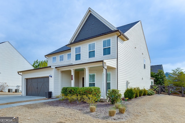 view of front of house with fence, central AC, a garage, driveway, and a gate